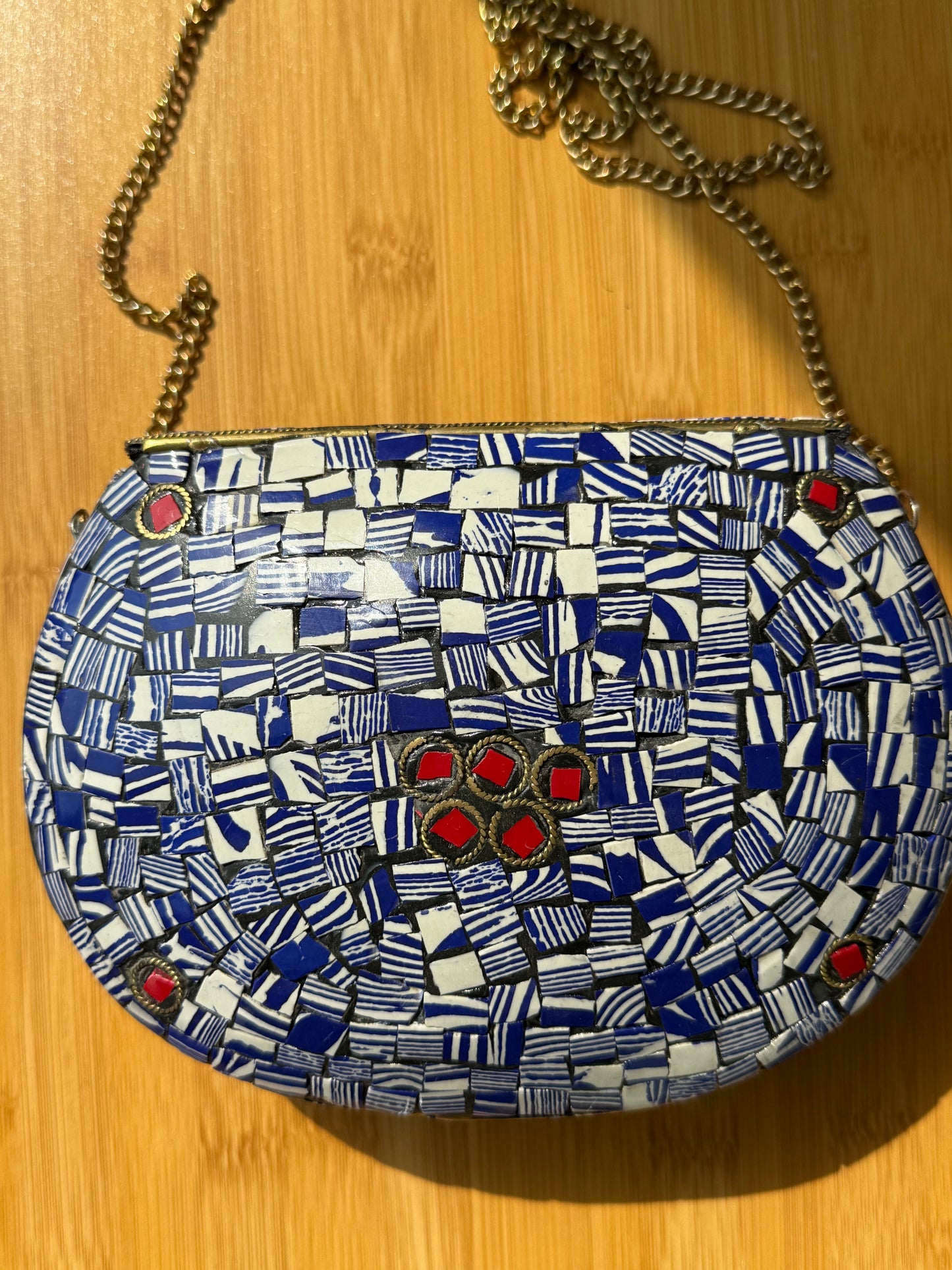 Colorful patterned bag with red accents on a wooden surface