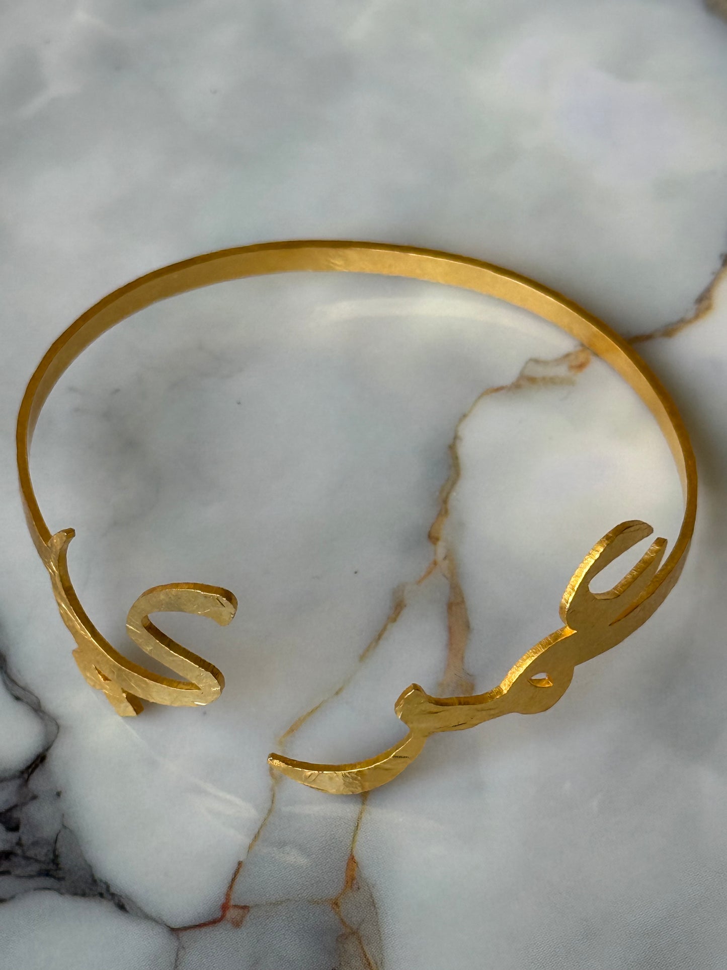 Gold-plated Arabic calligraphy bangle with the word “Ummry” (عمري), meaning My Love / My Life, handmade and ethically crafted by women artisans for Suzy’s Treasures.
