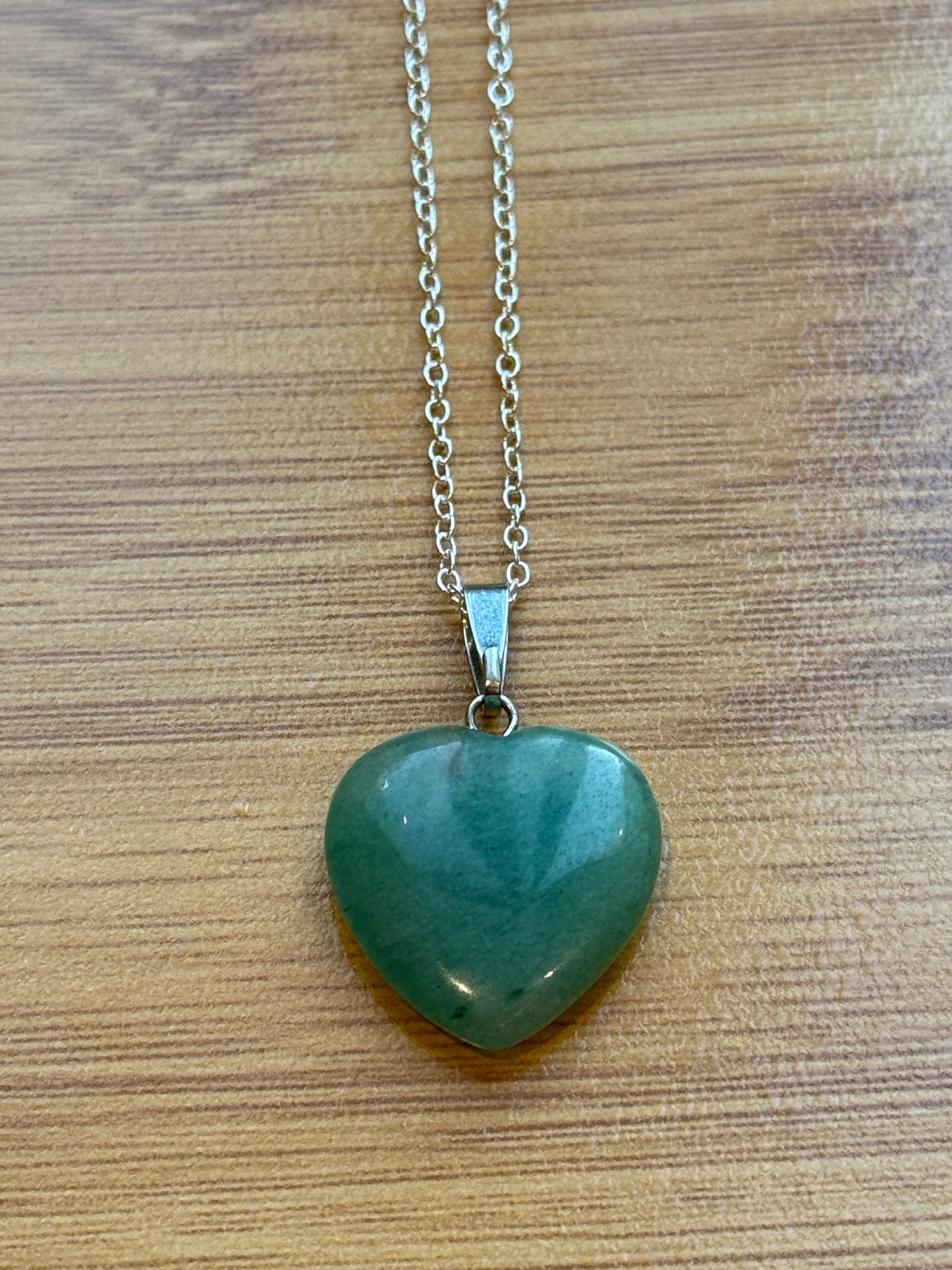 Green Aventurine pendant in heart shape with sterling silver chain on wooden background β Suzys Treasures