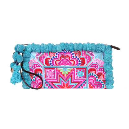 Close-up of the Pom Pom Clutch Bag from Suzys Treasures, featuring intricate hand embroidery in vibrant pink, turquoise, and red tones, framed with playful turquoise pom-poms and a tassel charm for a bold boho statement.