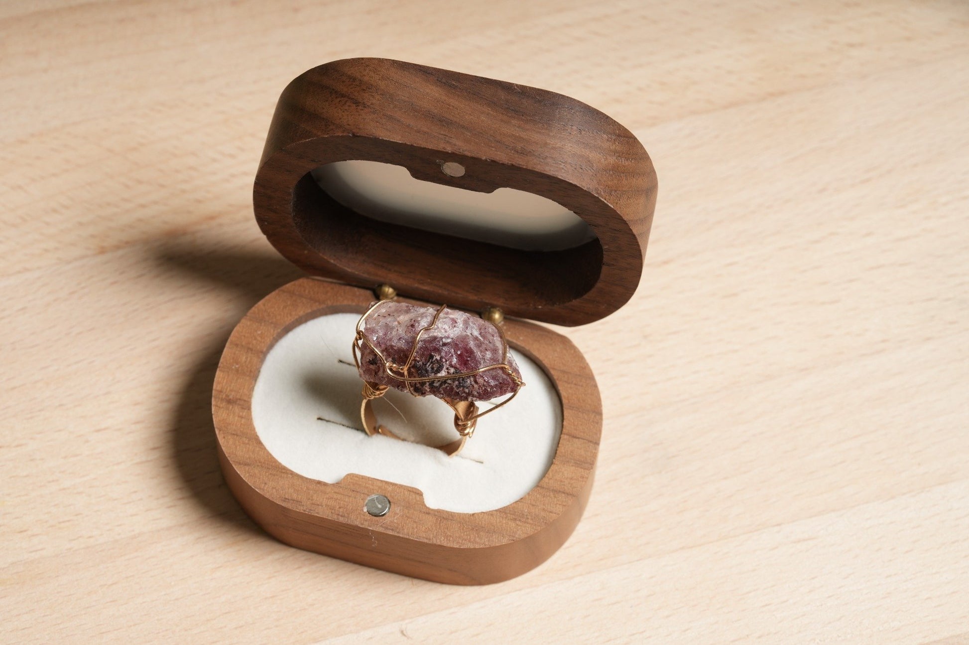Raw Strawberry Quartz crystal ring wrapped in gold-plated wire, displayed in a wooden ring box – Suzys Treasures handcrafted healing jewelry.