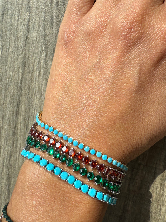 Close-up of a wrist wearing colorful beaded bracelets on a neutral background