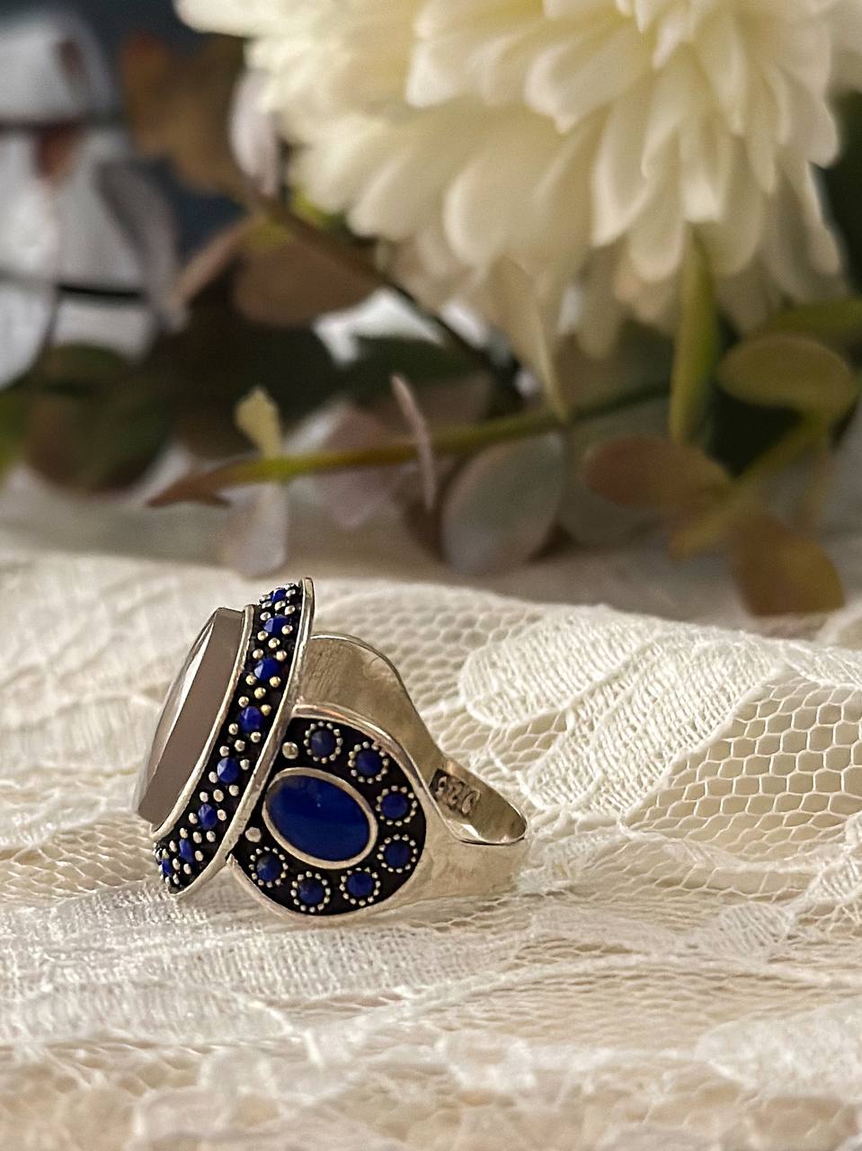 Suzys Treasures handcrafted women’s ring featuring Yemeni dendritic agate and intricate blue enamel detailing, set in sterling silver and displayed in a soft, elegant setting.