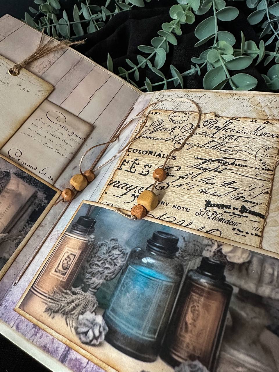 Handmade vintage-inspired journal featuring feathers, apothecary bottles, and lace detailing – a whimsical creation from Suzys Treasures.