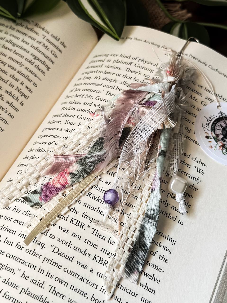 Handmade Boho tassel paperclip bookmark from Suzys Treasures, featuring pink and gold lace ribbons, pearl bead accents, and crochet trim, displayed on an open book – a charming and versatile accessory for journals, planners, or novels.