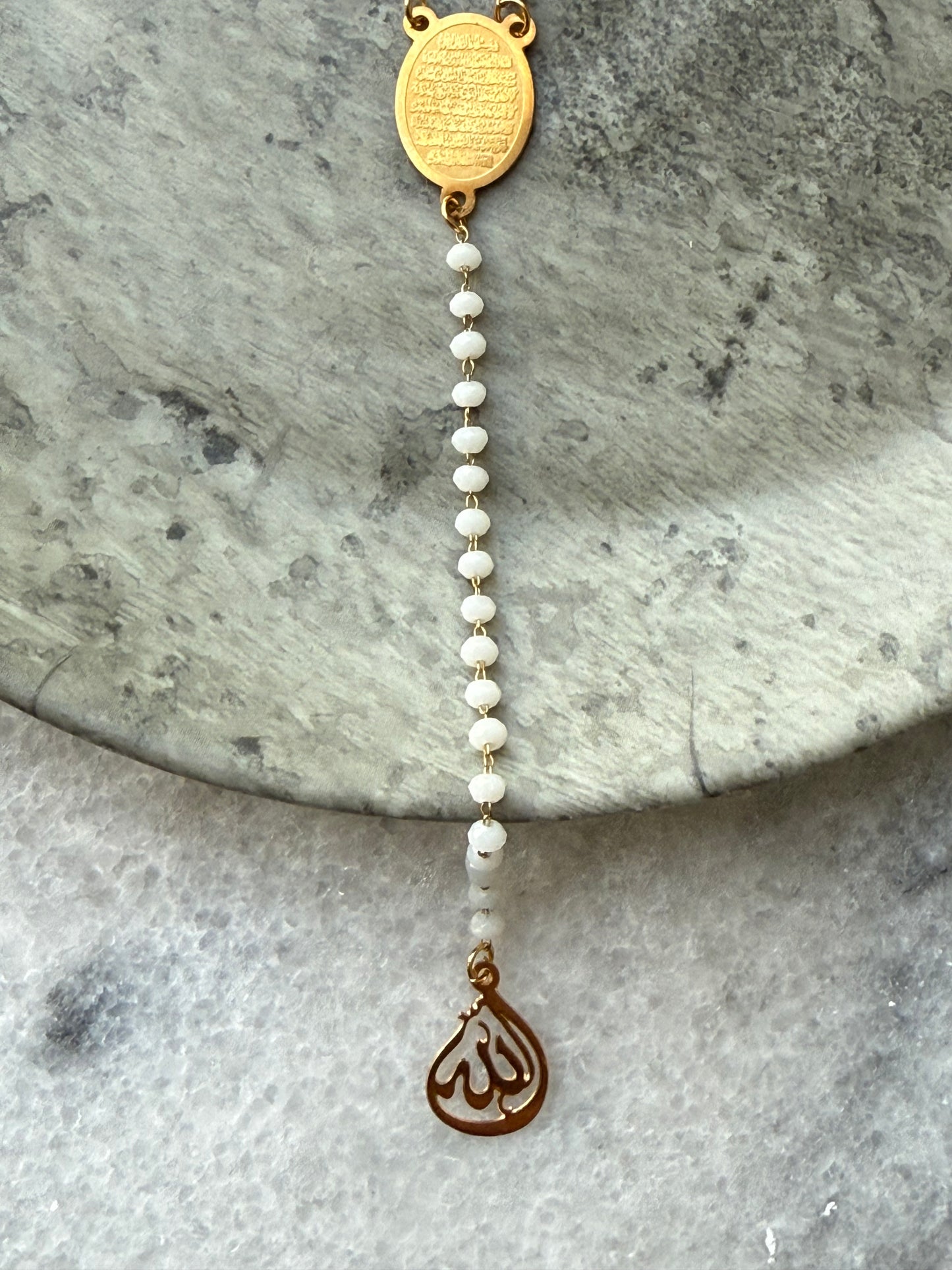 Islamic spiritual necklace with Ayat Al-Kursi engraved pendant and white beads, displayed flat by Suzys Treasures