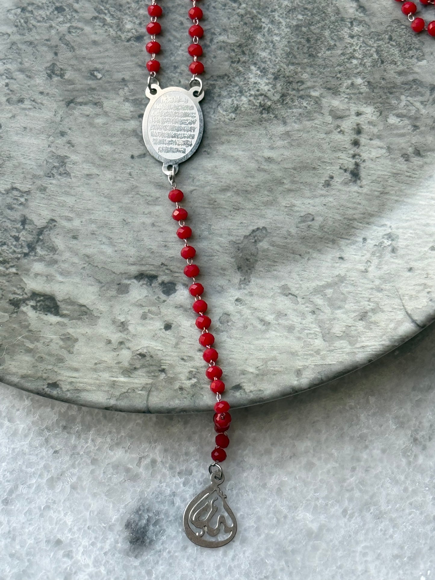Islamic spiritual necklace with Ayat Al-Kursi engraved pendant and red beads, displayed flat - Suzys Treasures