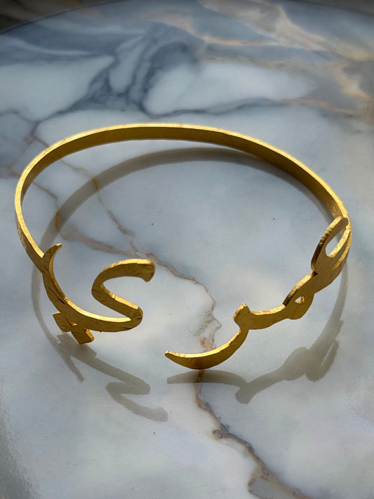 Gold-plated Arabic calligraphy bangle with the word “Ummry” (عمري), meaning My Love / My Life, handmade and ethically crafted by women artisans for Suzy’s Treasures.