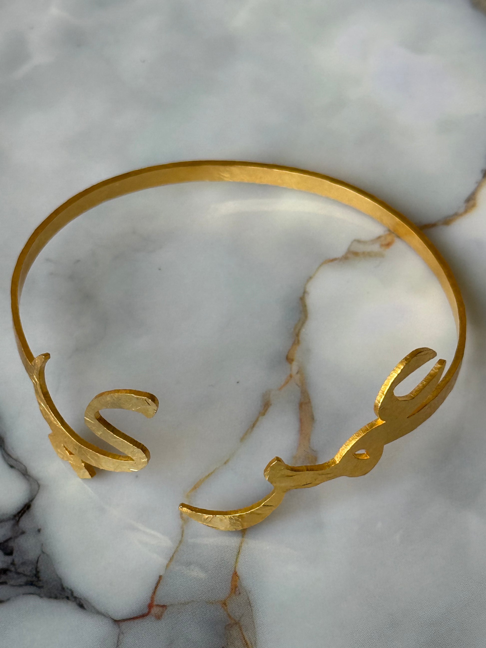 Gold-plated Arabic calligraphy bangle with the word “Ummry” (عمري), meaning My Love / My Life, handmade and ethically crafted by women artisans for Suzy’s Treasures.