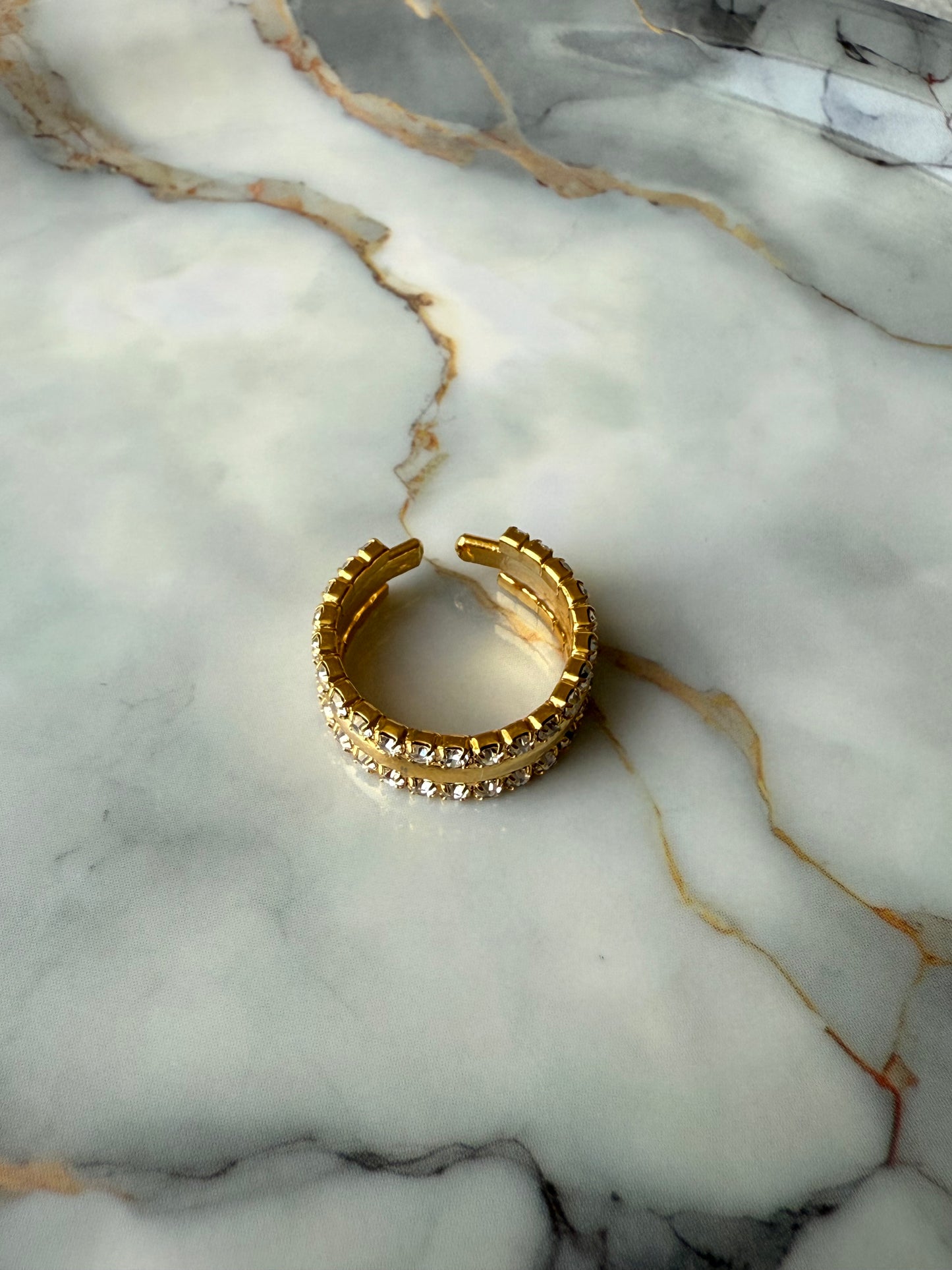 Adjustable copper ring with dual rows of zirconia on marble surface – elegant gold-tone jewelry by Suzys Treasures