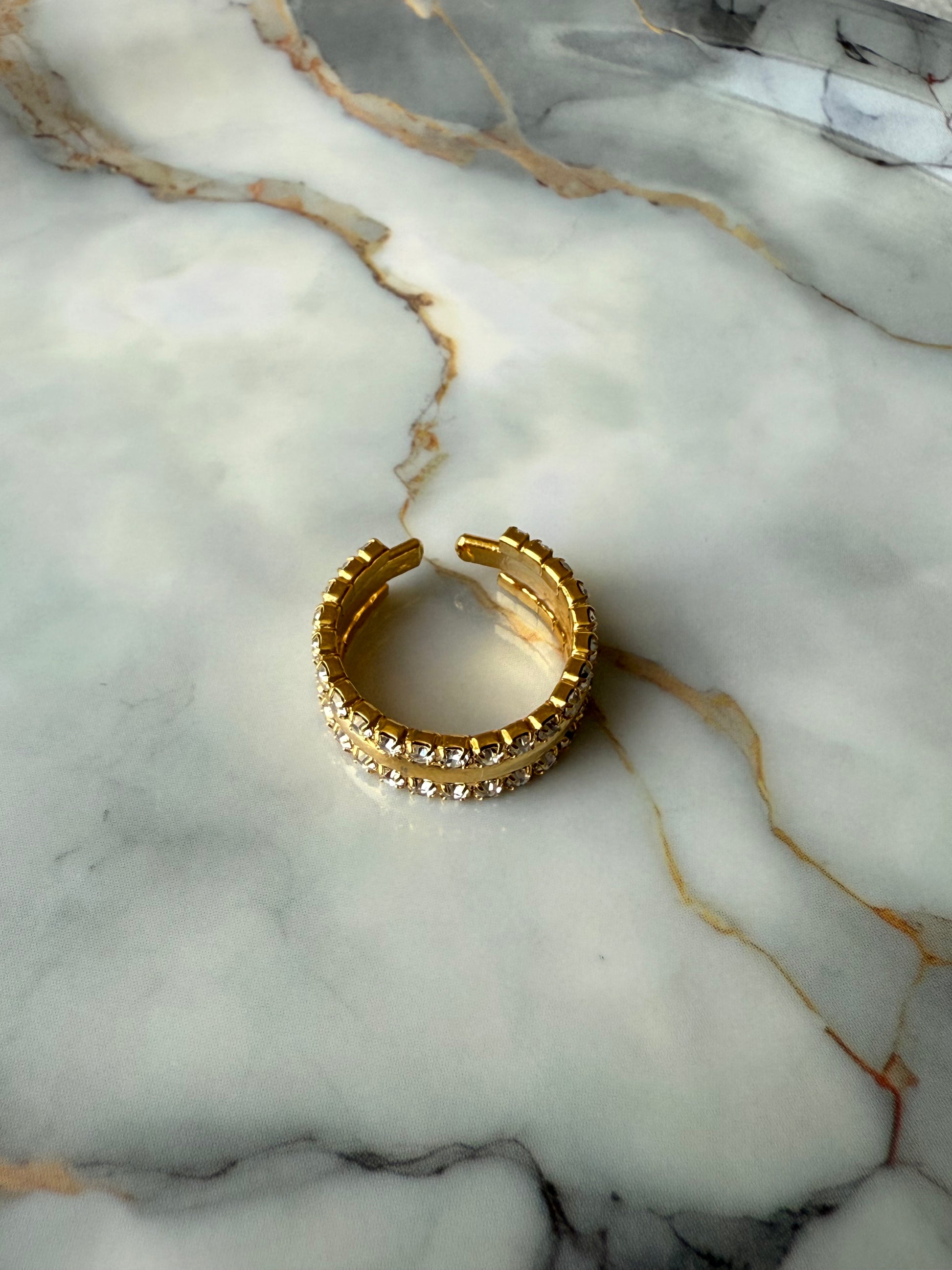 Adjustable copper ring with dual rows of zirconia on marble surface – elegant gold-tone jewelry by Suzys Treasures