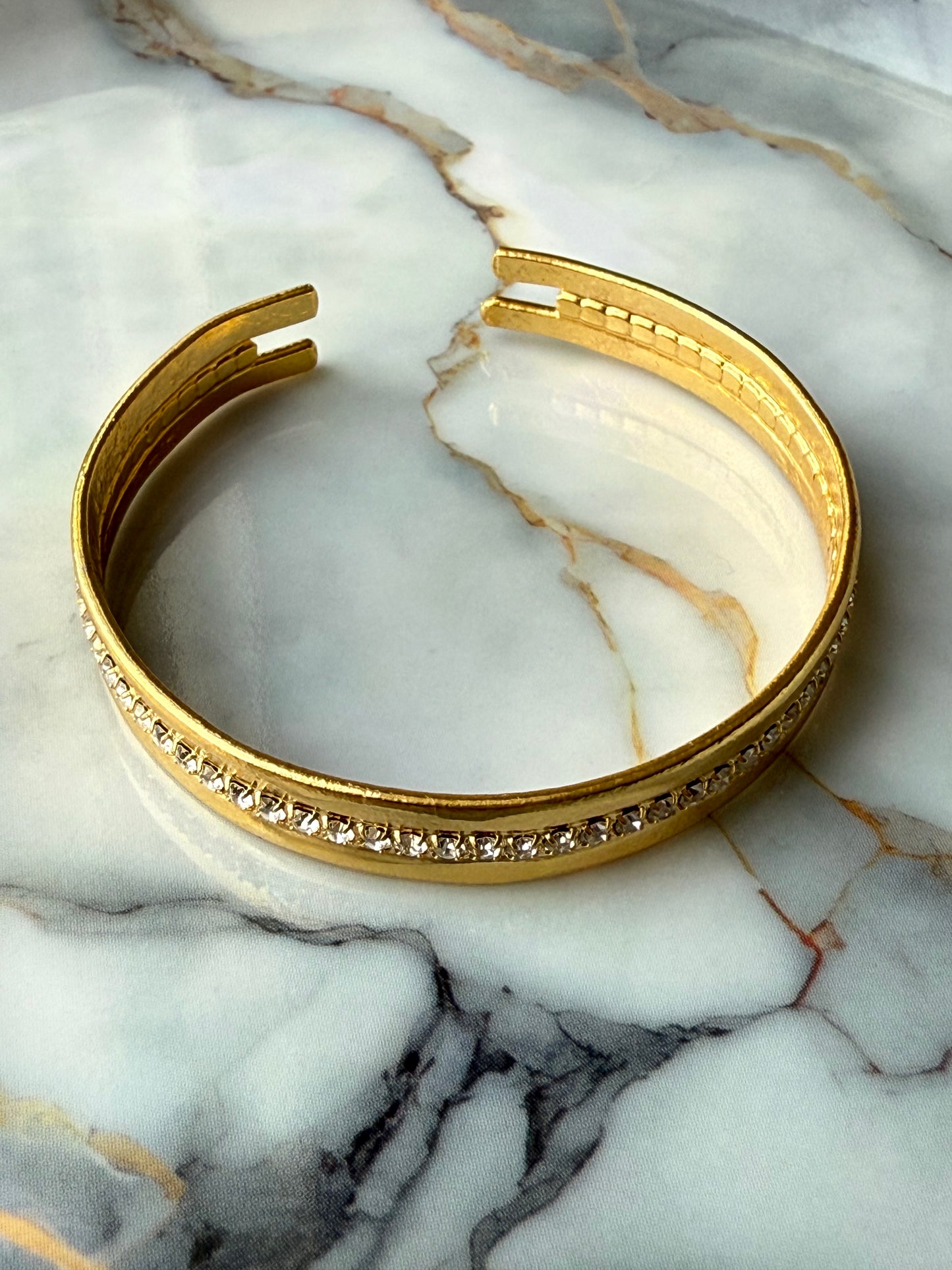 Minimalist copper bangle with single row zirconia crystals and 3-micron gold plating on marble background – Suzys Treasures