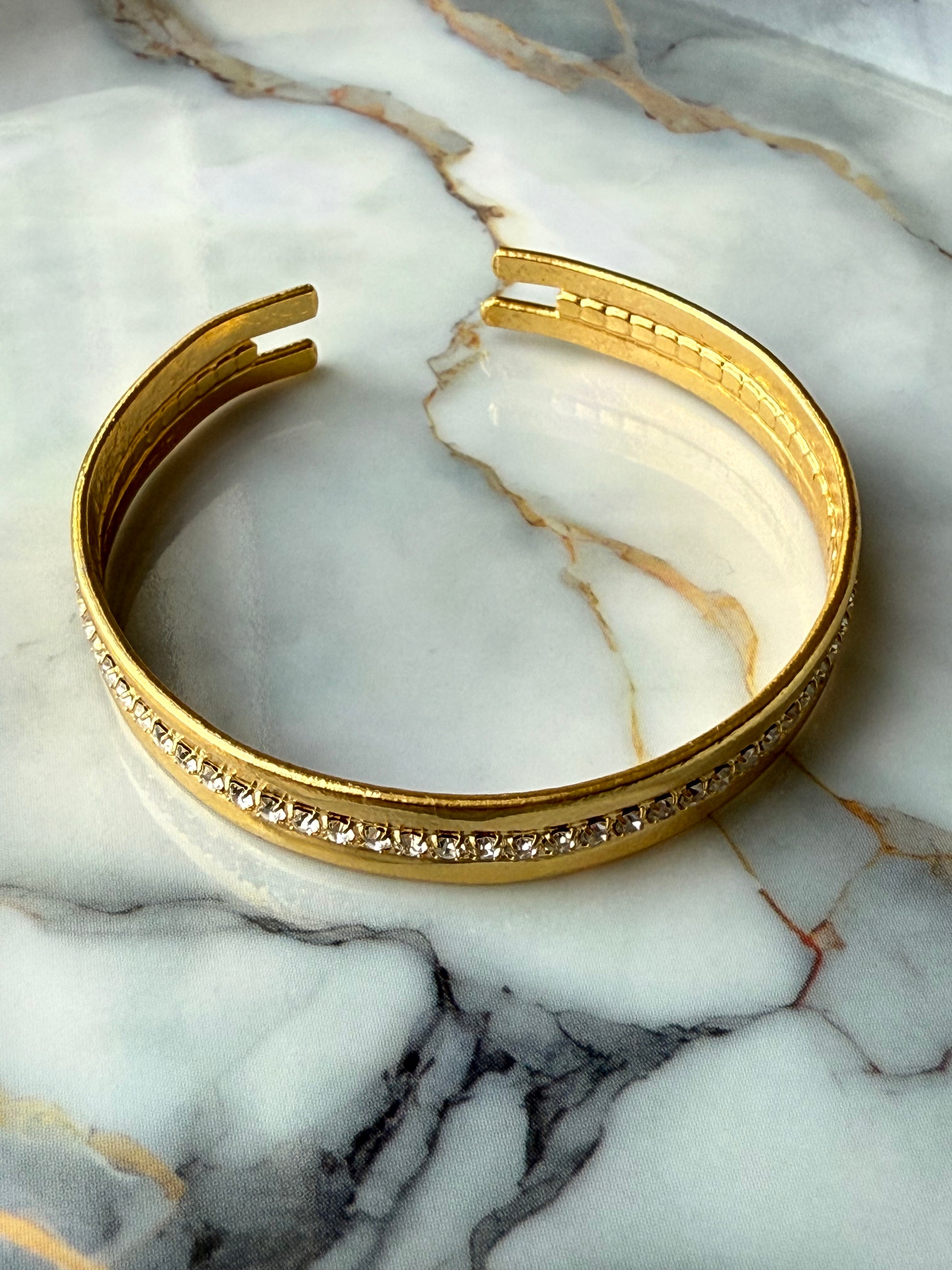 Minimalist copper bangle with single row zirconia crystals and 3-micron gold plating on marble background – Suzys Treasures