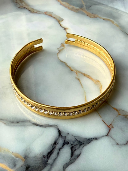 Minimalist copper bangle with single row zirconia crystals and 3-micron gold plating on marble background – Suzys Treasures