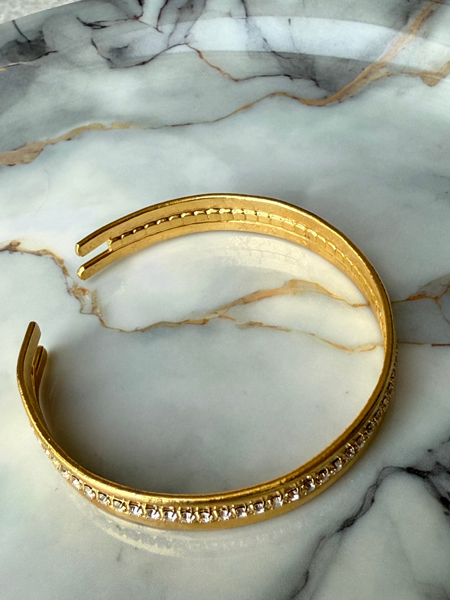 Minimalist copper bangle with single row zirconia crystals and 3-micron gold plating on marble background – Suzys Treasures
