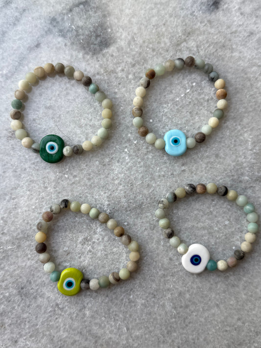 et of four crystal bead evil eye bracelets with Murano-style glass charms in green, blue, yellow, and white – handmade jewelry by Suzys Treasures