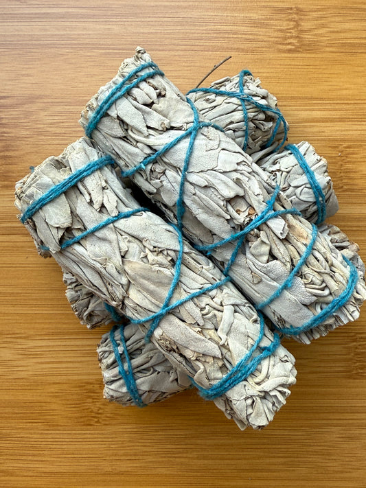 Hand-tied Californian white sage smudge sticks wrapped in blue string, sustainably sourced from the USA, for energy cleansing and purification, part of the Sacred Scents & Space collection by Suzy’s Treasures.