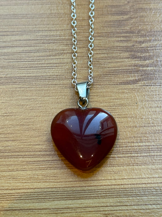Carnelian heart-shaped pendant with sterling silver chain on wooden background – Suzys Treasures