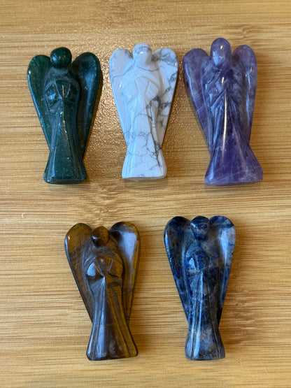 Five crystal angel figurines made of Amethyst, Howlite, Green Aventurine, Tiger’s Eye, and Sodalite on a wooden background – Suzys Treasures