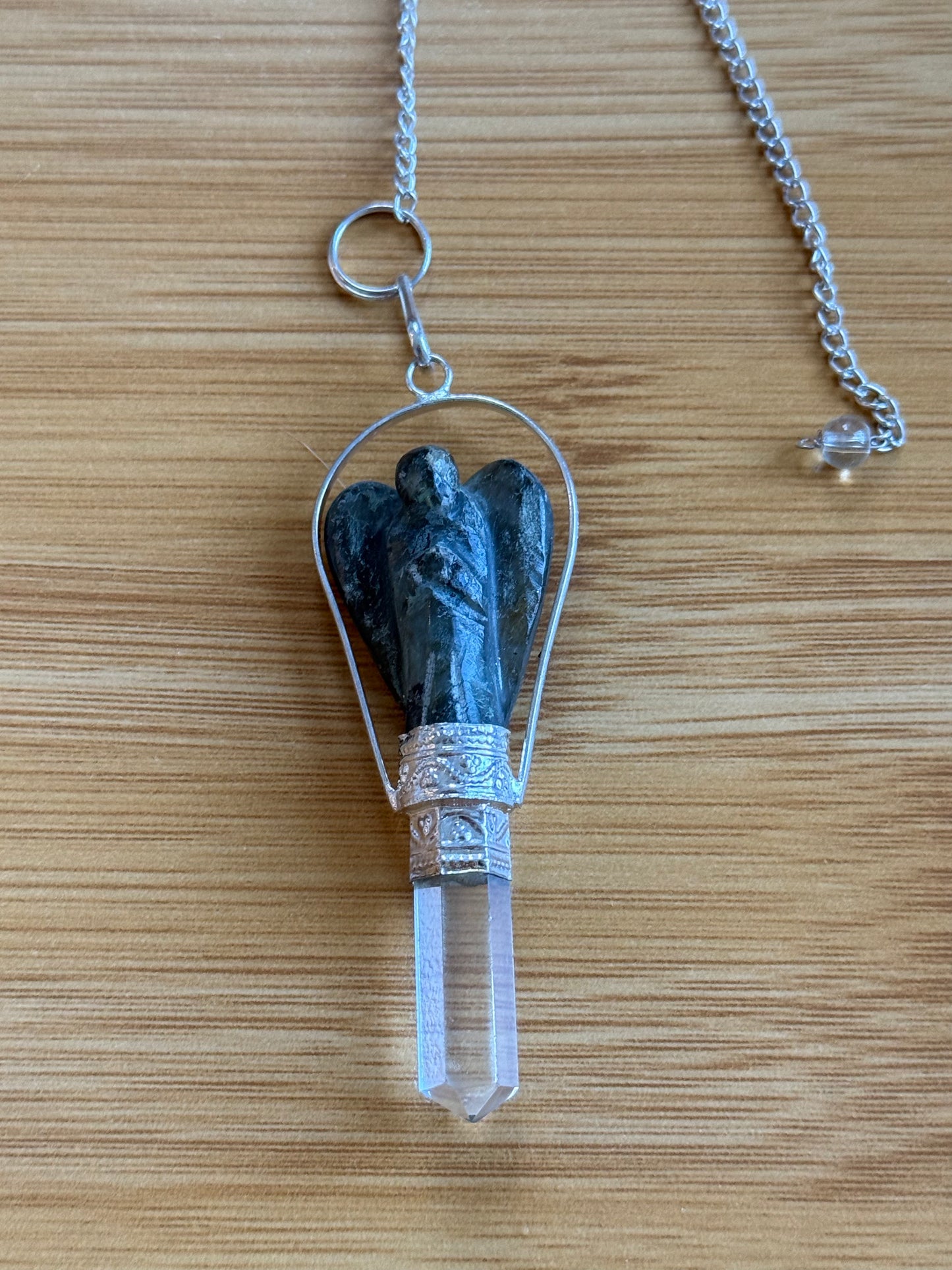 Labradorite angel crystal pendulum with quartz point and silver chain on wooden background – Suzys Treasures