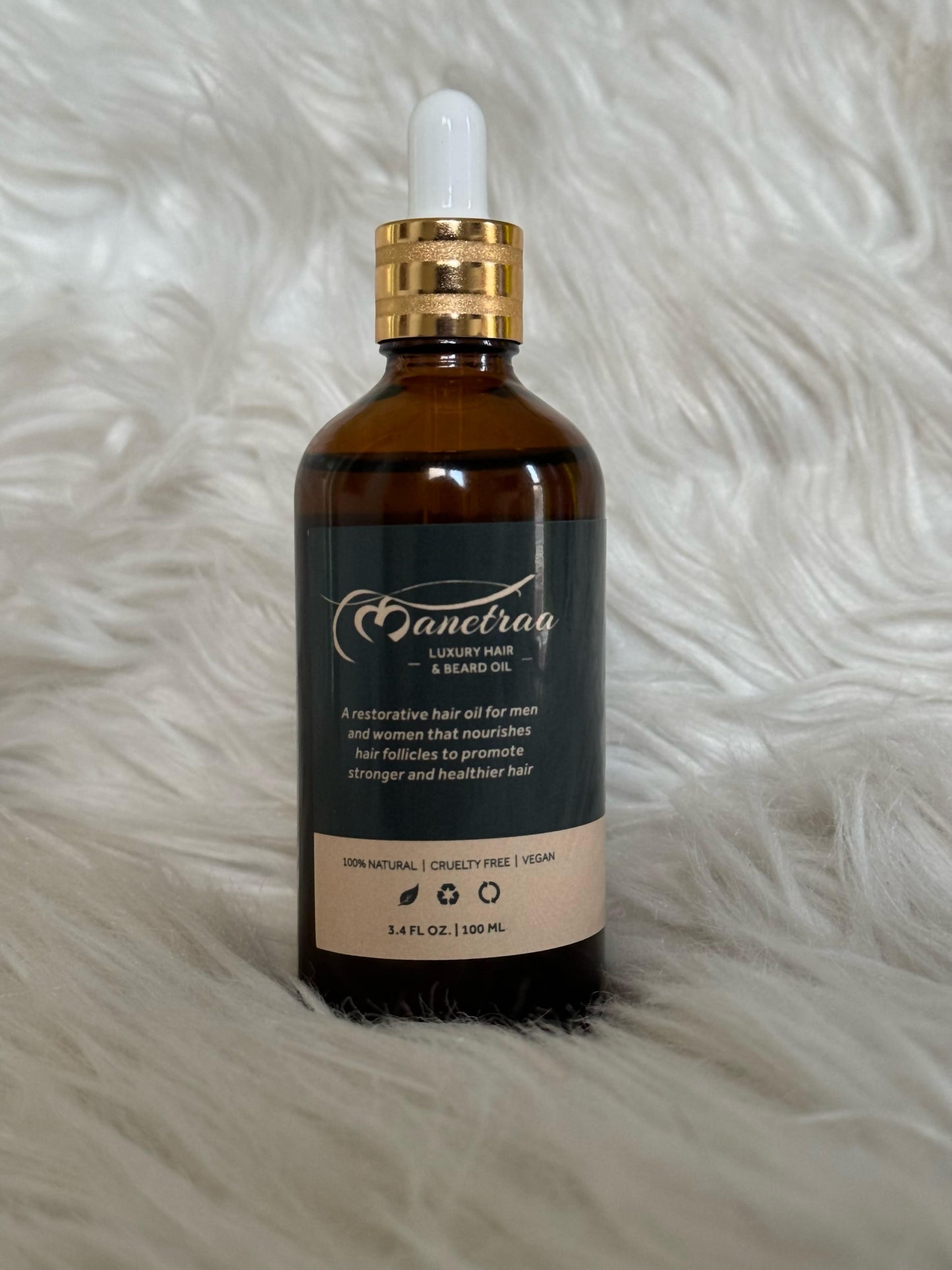 Suzy Treasures luxury Hair & Beard Oil in a dark amber glass dropper bottle with gold cap, displayed on a soft white faux fur background – a natural, cruelty-free, and vegan restorative oil for men and women.