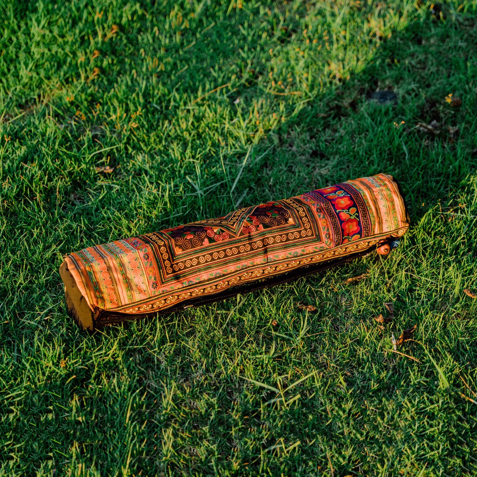 A colorful boho yoga bag with traditional ethnic patterns surrounded by lush greenery – Suzys Treasures.