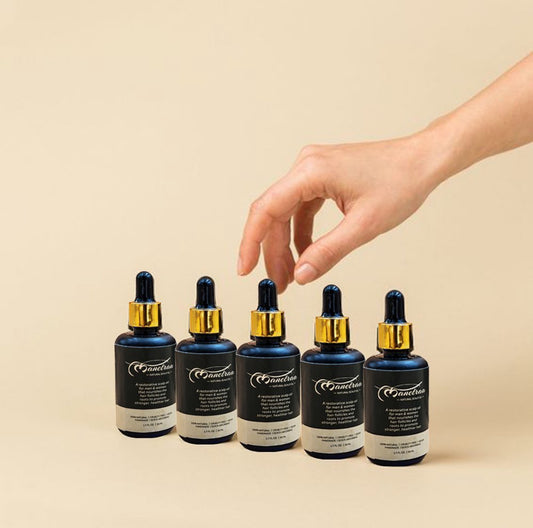 Suzy Treasures luxury Hair & Beard Oil in a dark amber glass dropper bottle with gold cap, displayed on a soft white faux fur background – a natural, cruelty-free, and vegan restorative oil for men and women.